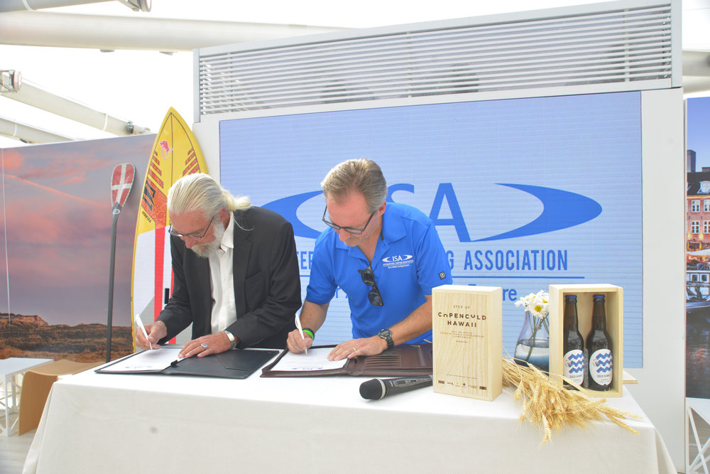 Finn Jorsal (left), president of Friends of Cold Hawaii, and Robert Fasulo (right), executive director, ISA, in the Danish National House in Rio, signing the COPENCOLD HAWAII – ISA World StandUp Paddle and Paddleboard Championship 2017 hosting agreement.